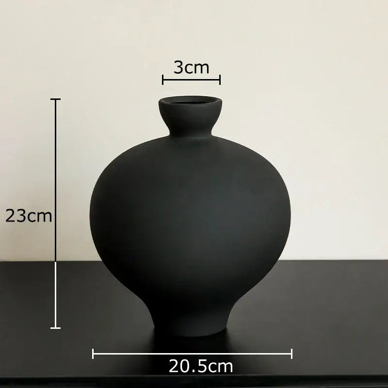 A sleek matte black big belly ceramic vase with rounded body and narrow neck for minimalist living room decor