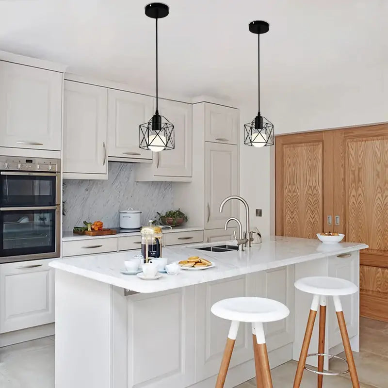 Black metal pendant light with geometric cage design and black finish hanging above kitchen island