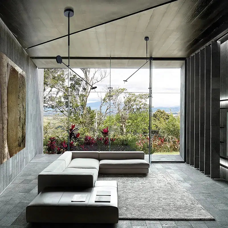 Modern minimalist sectional sofa in light gray leather paired with decorbites black metal pendant light for living room decor