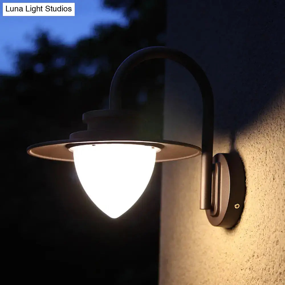 Minimalist black metal outdoor wall sconce with curved arm, frosted glass shade, and 60w maximum bulb wattage