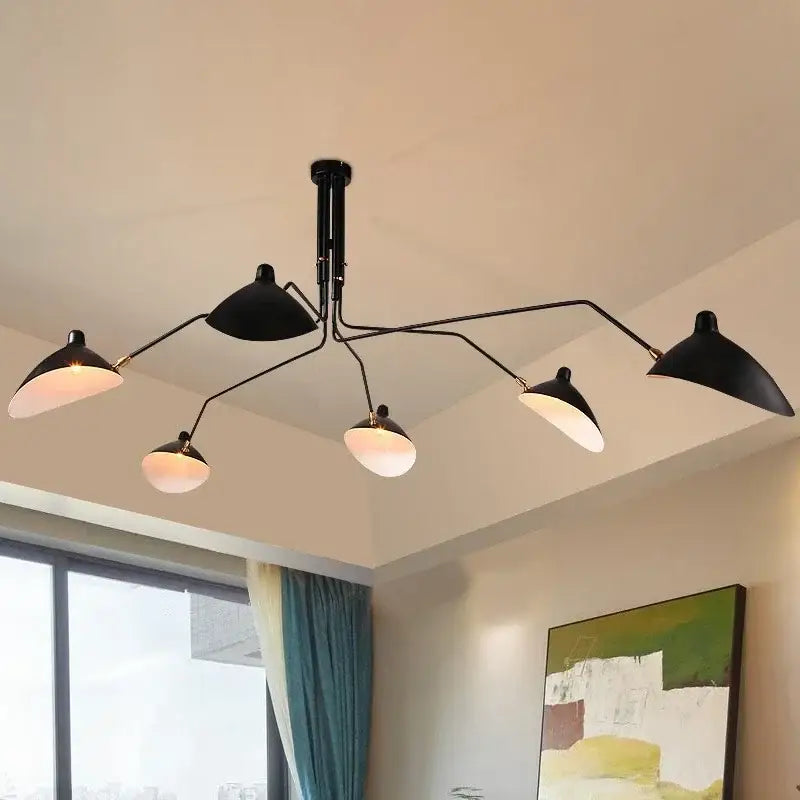 Minimalist black metal pendant light with five angled bell-shaped shades emitting warm light for dining table