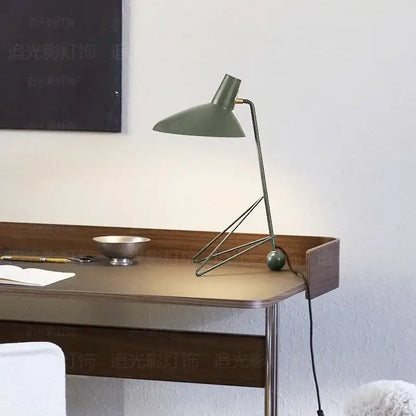 Minimalist olive green metal tripod desk lamp with sleek angular design for bedroom or office use