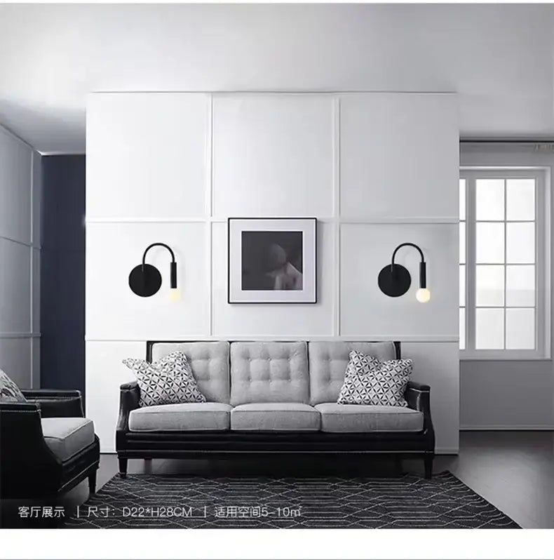 Black modern wall lamp with curved sconce and circular base featuring an exposed bulb for minimalist bedroom decorbites design
