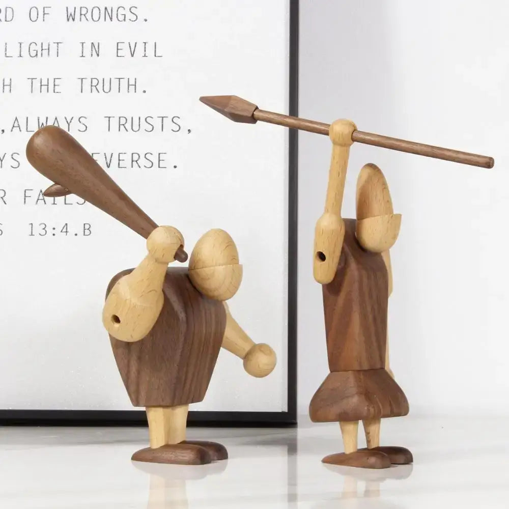 Two minimalist black and natural wood carving figurines featuring baseball bat and spear designs for living room decor