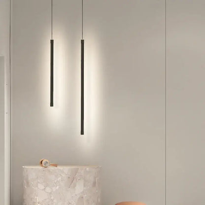 Two sleek black cylindrical decorbites black nordic led pendant lights hanging in kitchen dining room decor