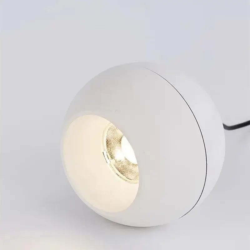 Minimalist black and off-white die-cast aluminum pendant light with white spherical shade and warm glowing acrylic lamp holder