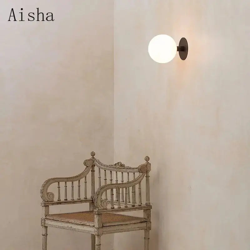 Minimalist black wall lamp with frosted white glass globe and matte black metal base lighting fixture decorbites gold