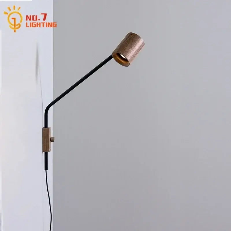 Minimalist wall lamp with a sleek black metal arm and walnut swing arm wooden head mounted by wood bracket