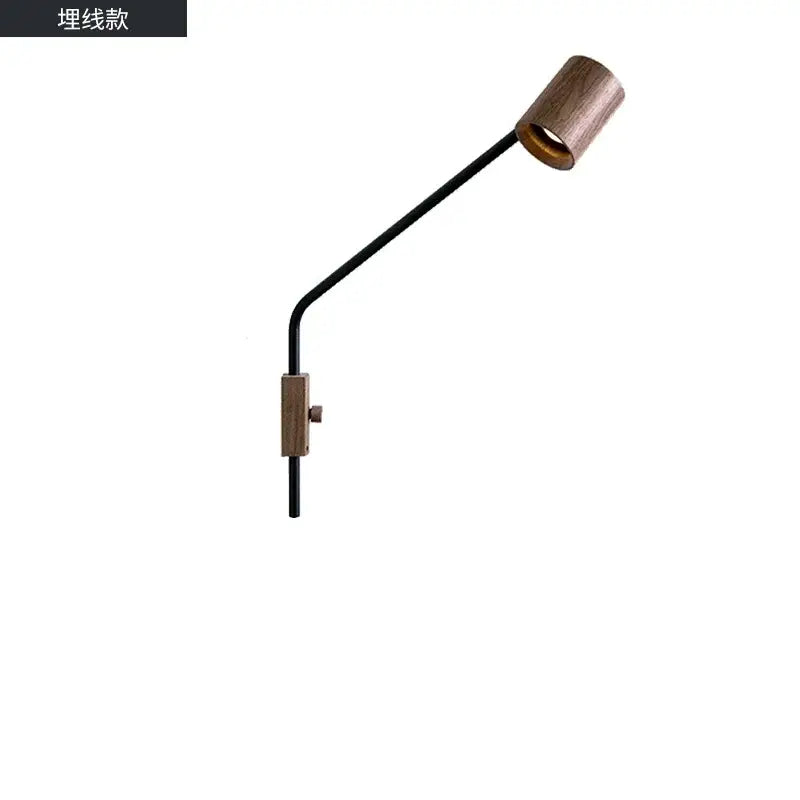 A sleek black metal wall lamp with a cylindrical black walnut swing arm shade for minimalist bedroom decor