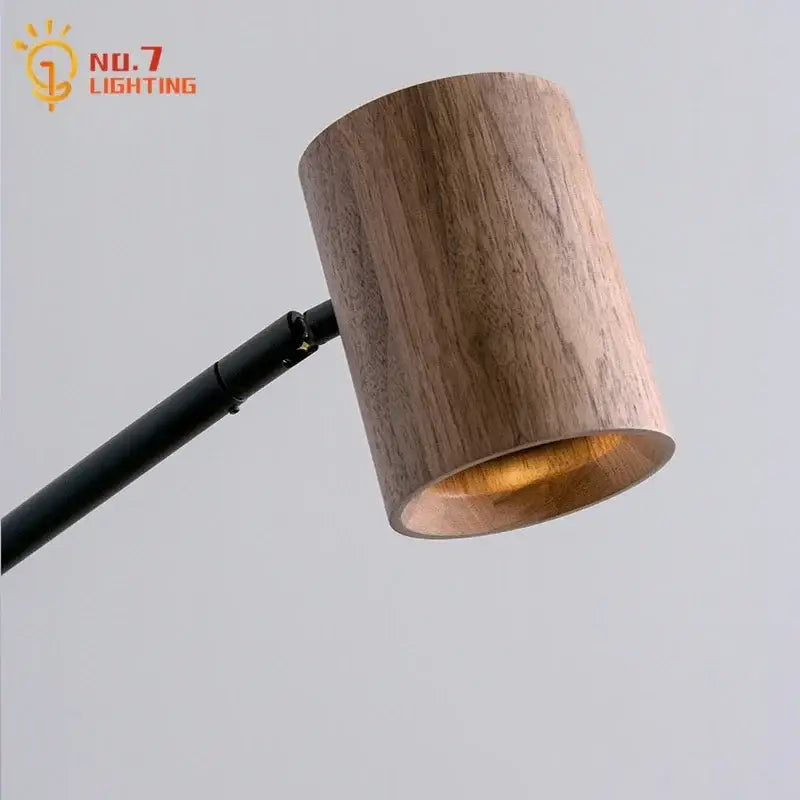 Minimalist black walnut swing arm wall lamp with a cylindrical wooden lampshade and warm brass interior lining