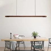Minimalist black walnut wood pendant light with brass ends hangs above dining table for modern decorbites pendant lights