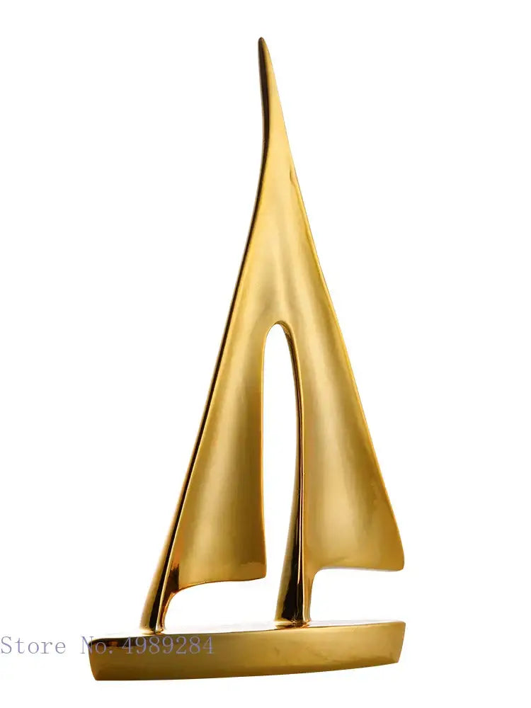 Golden metallic abstract resin sailboat sculpture with sleek minimalist design and polished finish for decorbites living room decor