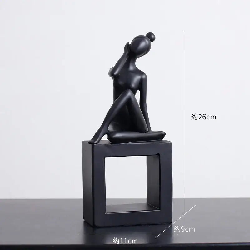 Minimalist black matte abstract resin sculpture of a seated woman with raised hand on square base for decorbites abstract decor