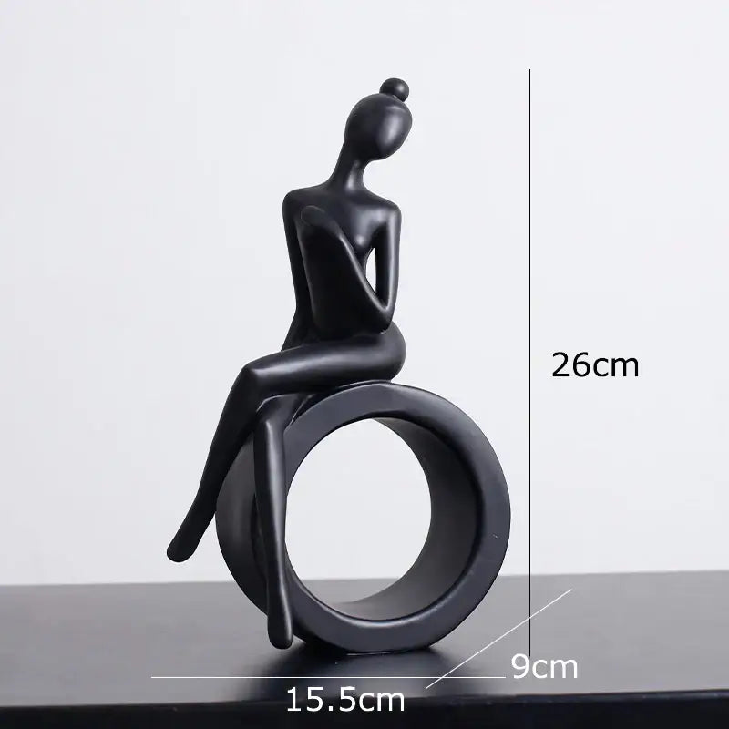 Minimalist black and white decorbites abstract resin sculpture of seated woman with bun on circular ring base for living room decor