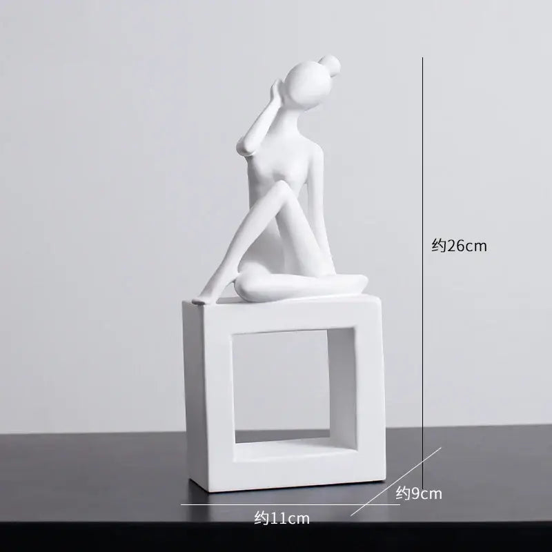 White ceramic figurine of a seated woman on a square base in minimalist black and white decorbites abstract resin sculpture