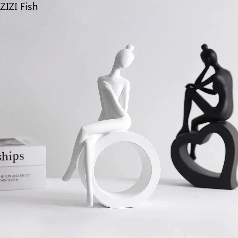 White ceramic figurine of seated woman hair in bun on circular base minimalist decorbites abstract resin sculpture