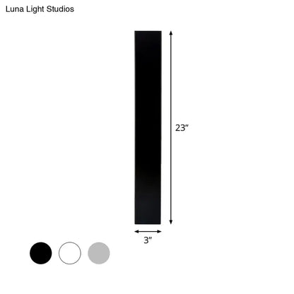 Minimalist black rectangular aluminum shade direct wired sconce measuring 23 inches tall and 3 inches wide for bedroom use