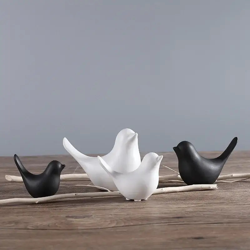 Minimalist black and white ceramic bird figurine set arranged on driftwood for living room decor