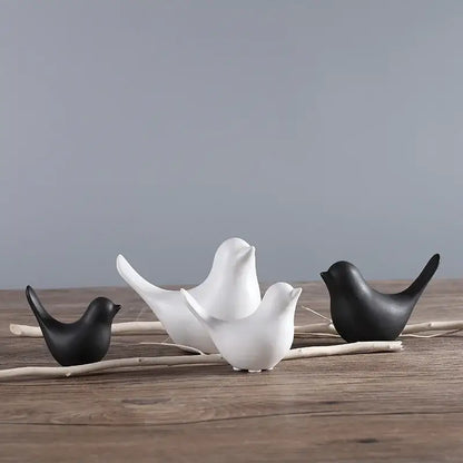 Minimalist black and white ceramic bird figurine set arranged on driftwood for living room decor