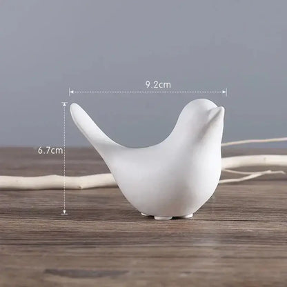 White ceramic bird figurine with smooth minimalist design and rounded features in a black and white figurine set