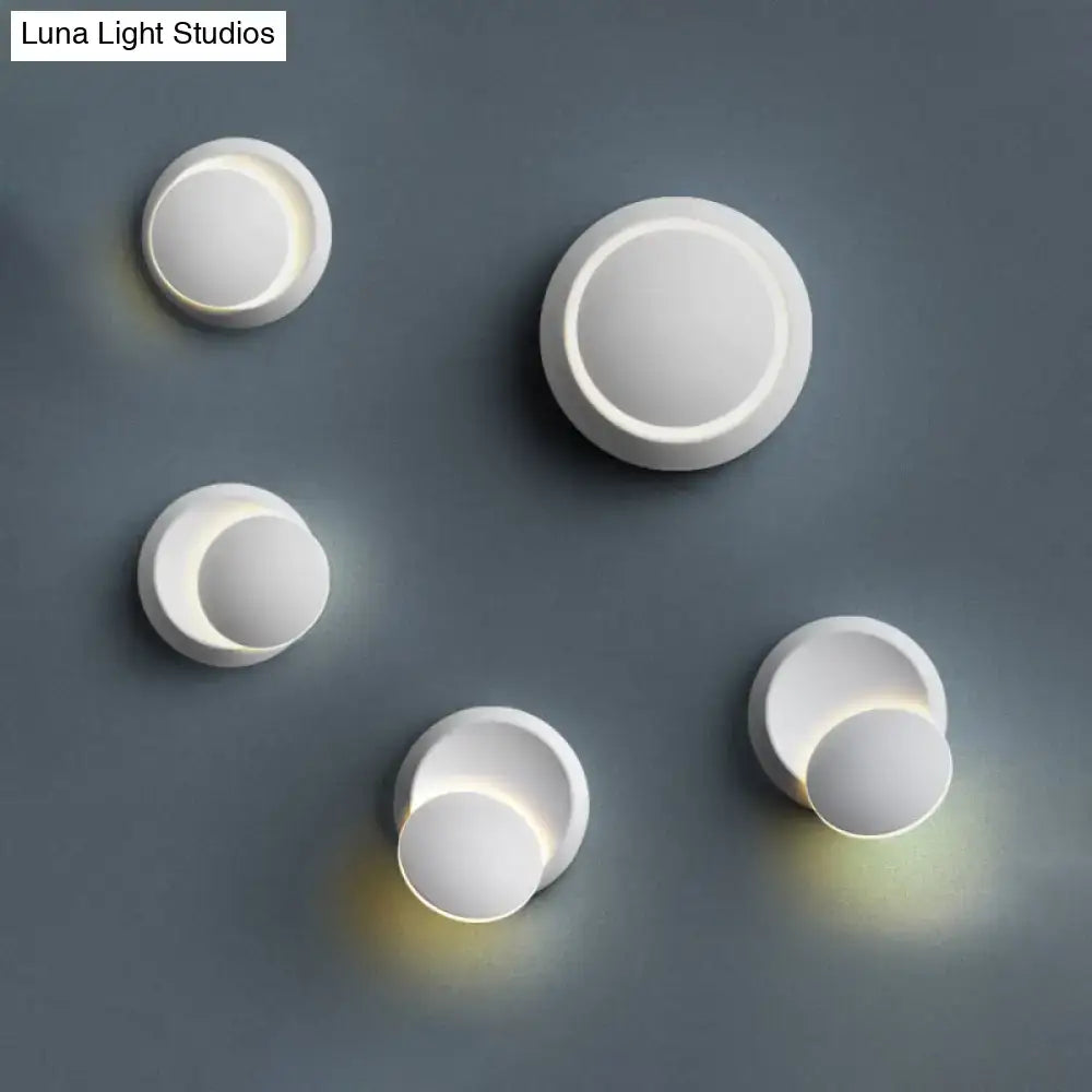 Minimalist black and white circular led wall lamp with white circular sconces emitting warm glow for stairway lighting