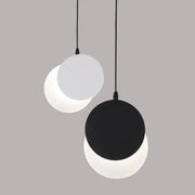 Minimalist black and white crescent moon pendant chandelier with two circular matte shades hanging on black cords by decorbites