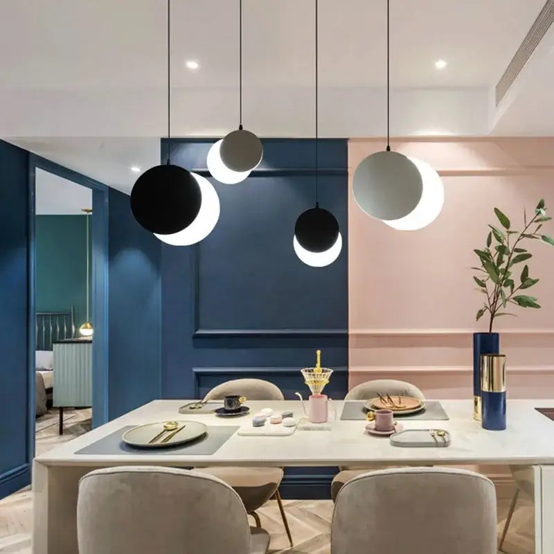 Modern black and white crescent moon pendant chandelier with minimalist spherical lights by decorbites above dining table
