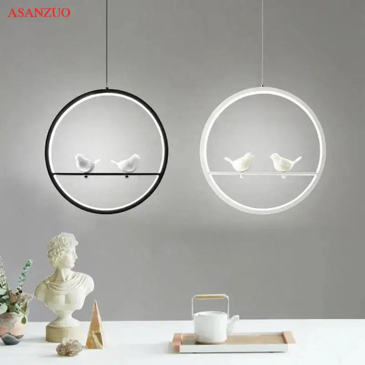 Two minimalist circular pendant lights with black and white frames featuring white ceramic birds decorbites bird chandelier