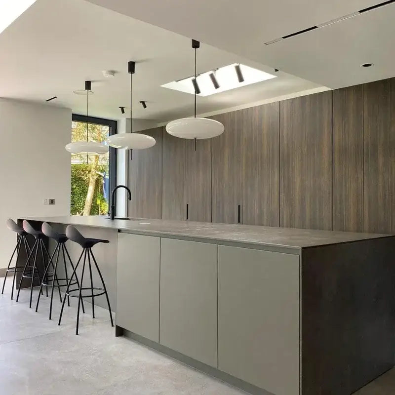 Modern minimalist kitchen island with matte gray countertop and warm wood cabinetry under decorbites designer pendant light