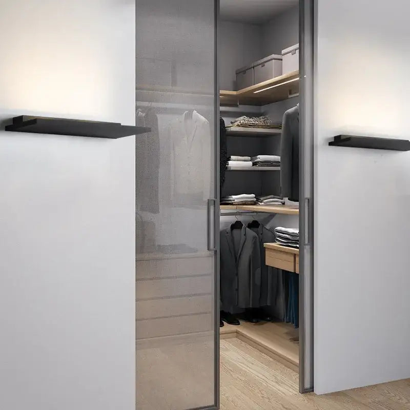Modern minimalist sliding glass closet door with metallic frame and frosted panel paired with decorbites led wall light