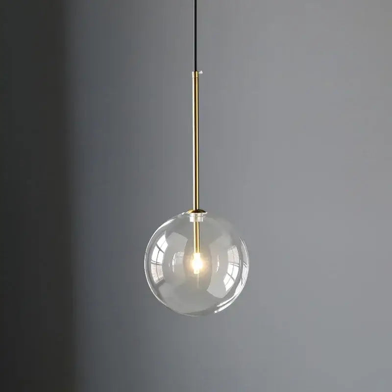 Minimalist pendant light with brass-toned metal rod and decorbites clear glass ball for dining room decor