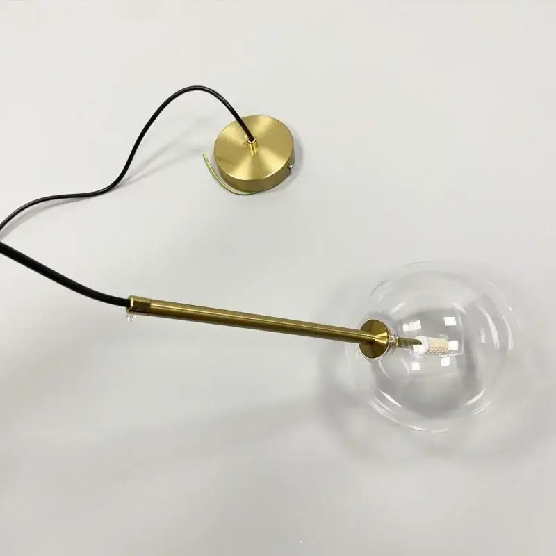 Minimalist brass pendant light with a clear glass ball and sleek circular base for decorbites clear glass dining room lighting