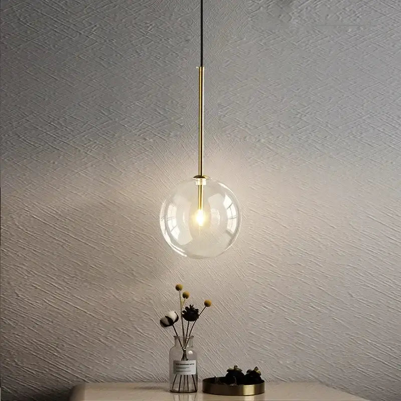 Minimalist brass and clear glass ball pendant light with warm illumination for dining room decorbites clear glass design