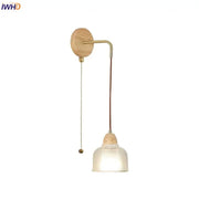 Minimalist brass wall light with natural wood base, clear glass ribbed shade, and pull chain switch for bedroom decorbites clear glass