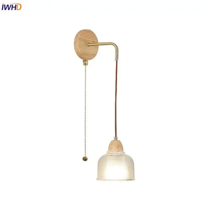 Minimalist brass wall light with natural wood base, clear glass ribbed shade, and pull chain switch for bedroom decorbites clear glass