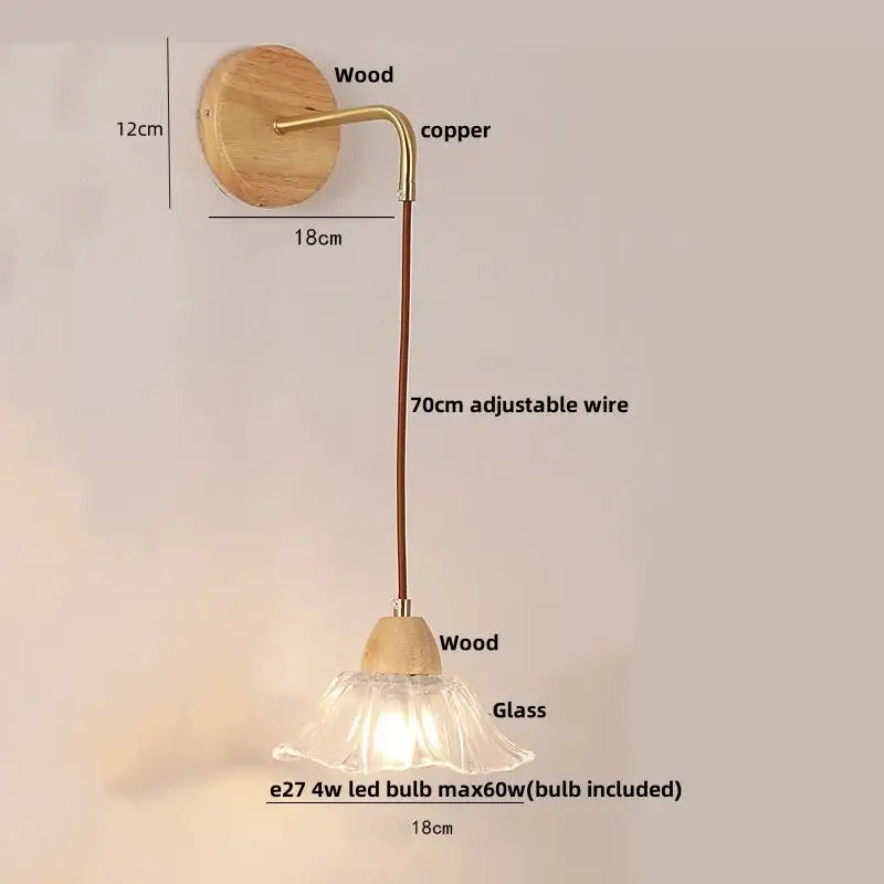 Minimalist brass wall light with clear glass bell shade and natural wood backplate featuring adjustable copper wire decorbites clear glass