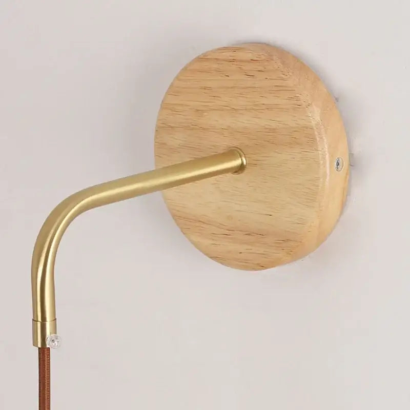 Minimalist brass wall light with clear glass and round light wood backplate featuring a pull chain switch decorbites clear glass