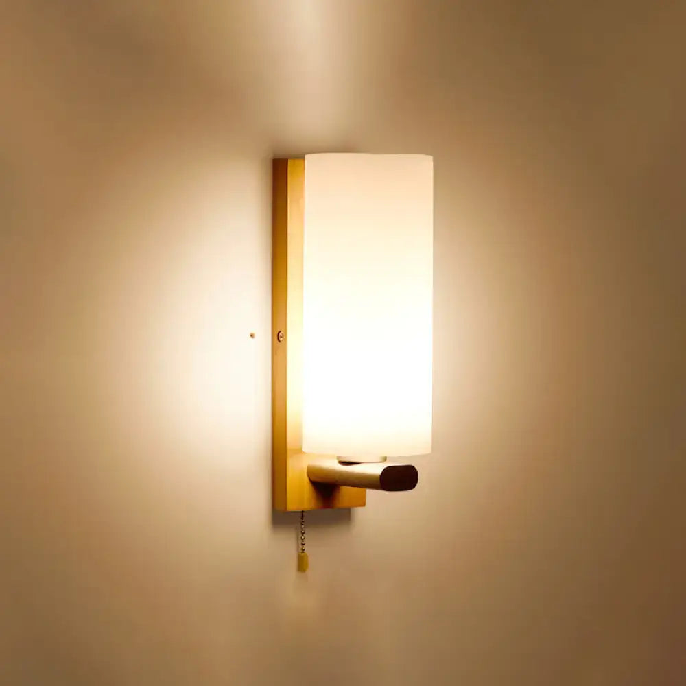 Minimalist brass and glass geometric wall sconce with warm-toned frosted glass shade for bedroom lighting