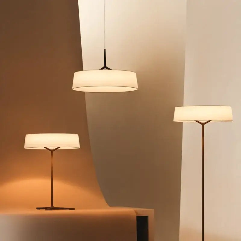 Modern minimalist dama pendant lamp and floor lamps with sleek brass frames and off-white fabric shades for kitchens