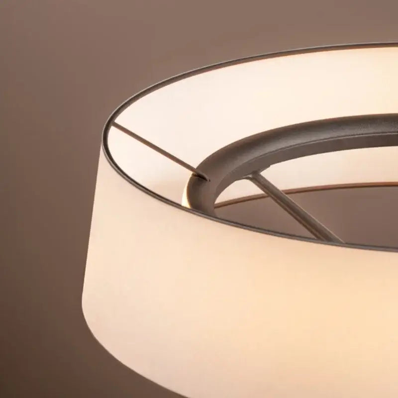 Minimalist dama pendant lamp with off-white fabric shade and dark metal frame providing warm kitchen lighting