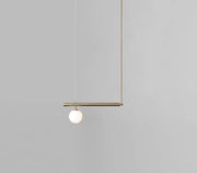 Minimalist brass ceiling light with a white glass globe suspended from a horizontal bar for kitchen island use