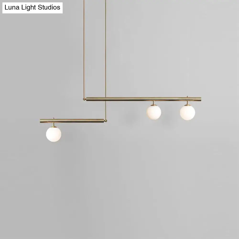 Modern brass ceiling light with three frosted white glass globe bulbs for kitchen island lighting