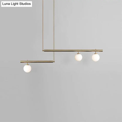 Modern brass ceiling light with three frosted white glass globe bulbs for kitchen island lighting