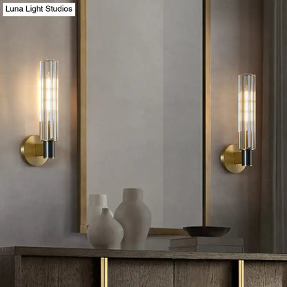 Minimalist brass finish tubular wall light sconce with gold-toned metal, clear glass tubes, and black accents for bedroom use