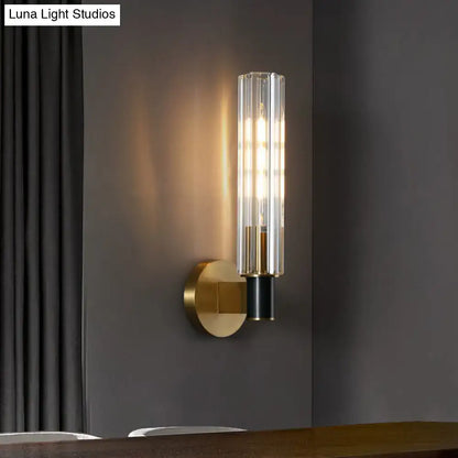Minimalist brass finish tubular wall light sconce with clear vertically ribbed glass cylinder for bedroom lighting