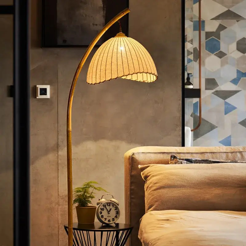 Minimalist brass led floor lamp with marble base and golden arched design featuring a woven warm-toned shade
