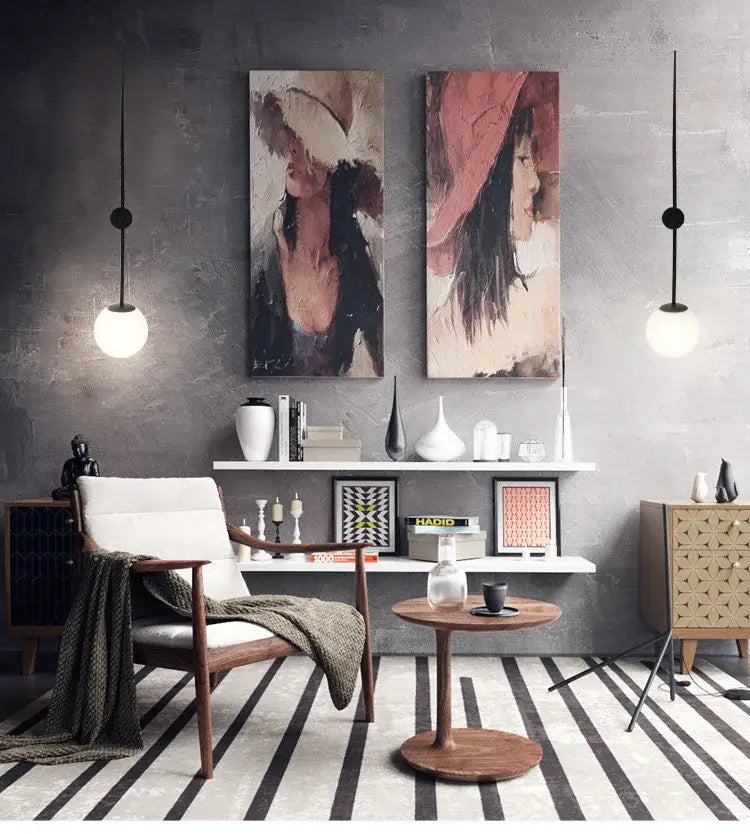 A modern wooden side table with round top and pedestal base beside minimalist brass led wall lights with frosted globe