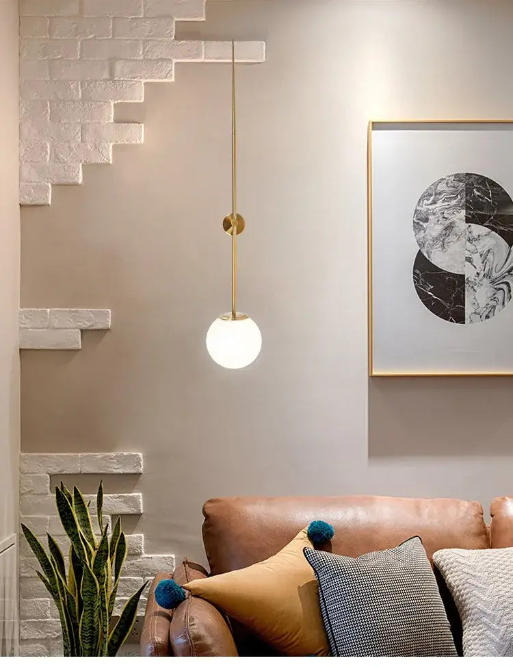 Minimalist brass led wall lights featuring a gold-toned pendant with a frosted globe for bedroom use