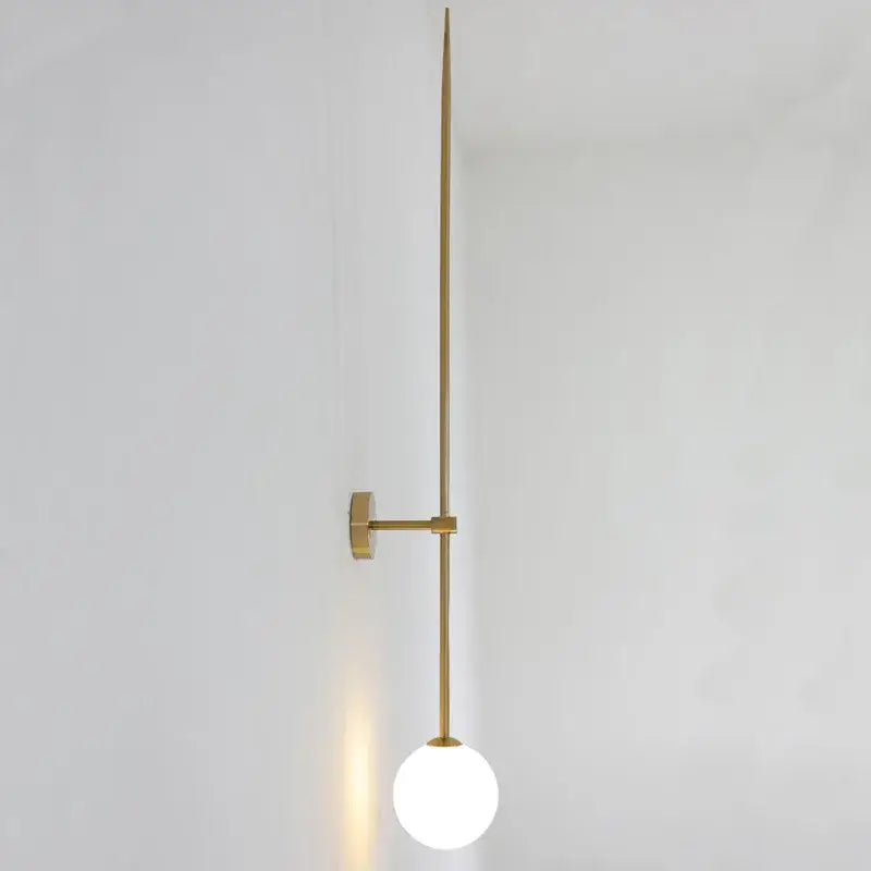 Minimalist gold-toned brass led wall lights with a slender rod and frosted globe for bedroom lighting