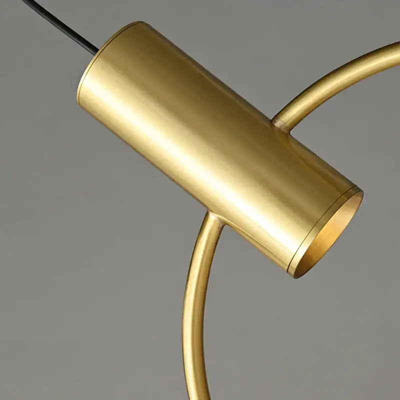 Minimalist brass ring chandelier with gold-finished cylindrical pendant light and curved metallic arms by decorbites brass ring